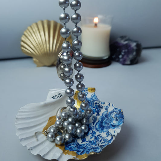 Grande conchiglia dorata, decorata con motivo sulla carta blue usato come porta collana di perle 